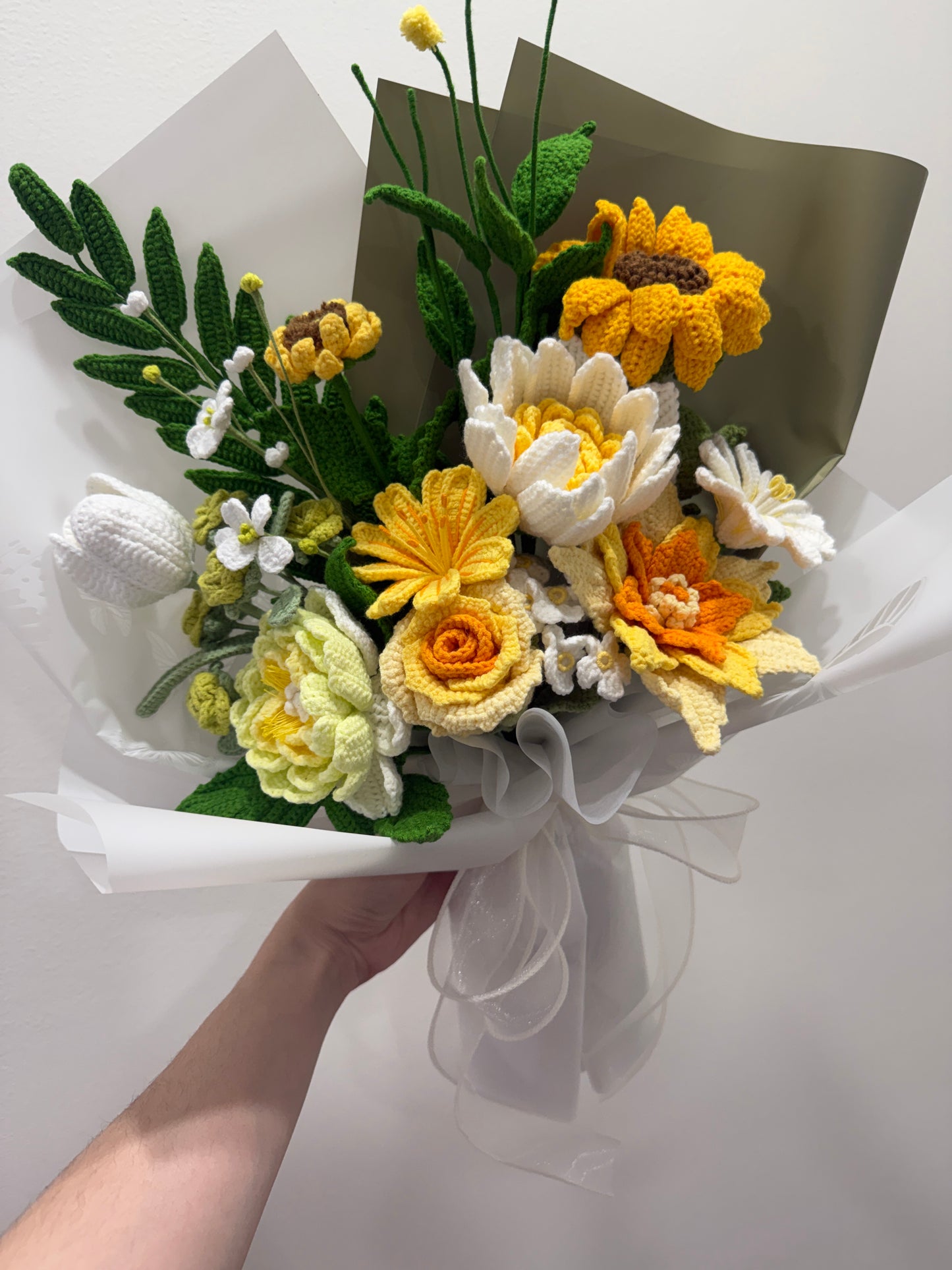 Knitted bouquet of yellow, white, and orange flowers on a white background